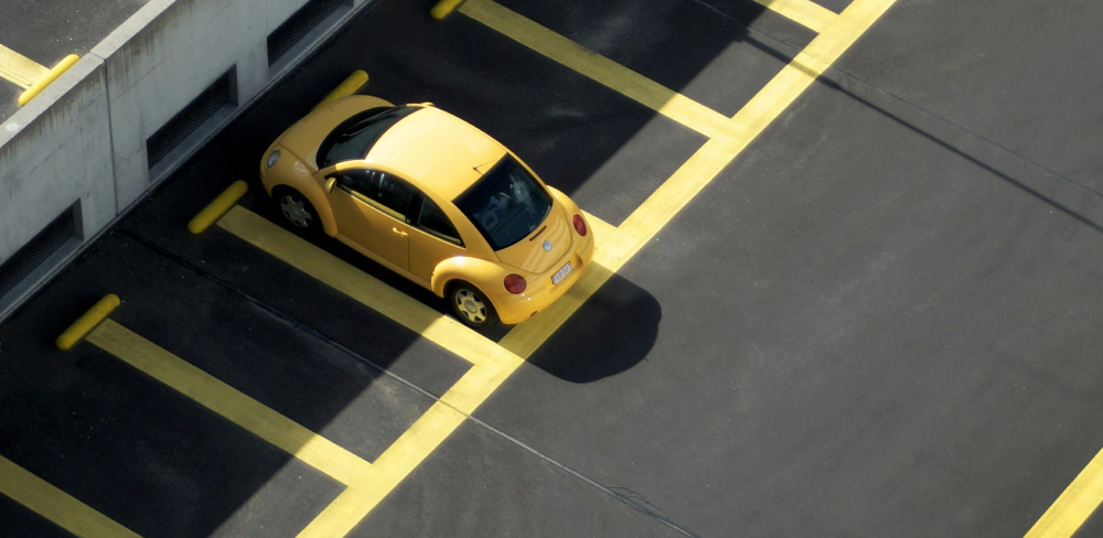 Żółty samochód na stanowisku parkingowym w Centrum Handlowym Wzorcownia